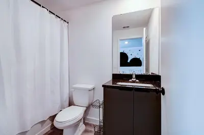 a bathroom with a toilet and a sink and a mirror at 3417 Brand New 3BD Family Home Near Disney in Kissimmee