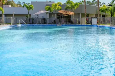 a large pool with blue water in front of a building at Luxury Studio Gem 10min to Disney Pool and Amenities in Kissimmee