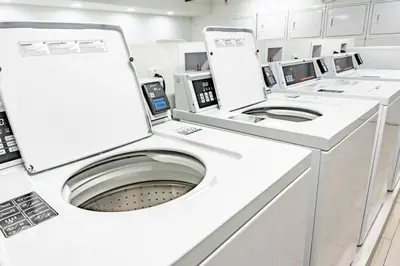 a white washing machine in a white room at Luxury Studio Gem 10min to Disney Pool and Amenities in Kissimmee