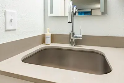a bathroom sink with a soap dispenser on it at Luxury and Cozy Gem 15min to Disney Free Parking in Kissimmee