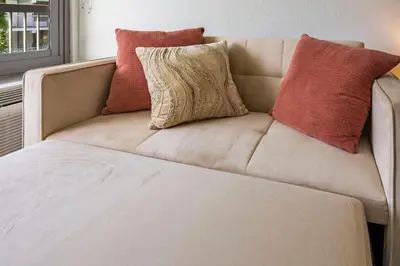 a couch with pillows on it in a room at Luxury and Cozy Gem 15min to Disney Free Parking in Kissimmee