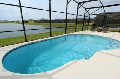 a large blue swimming pool with a view of the water at 4BDR with pool near Disney 1014 in Kissimmee