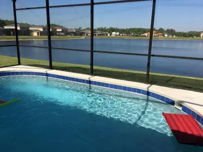 a swimming pool with a red bench and water at 4BDR with pool near Disney 1014 in Kissimmee