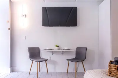 two chairs and a table with a tv on a wall at Modern New APT in perfect Location only 10min to Disney in Kissimmee