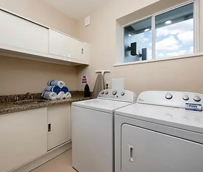 a laundry room with white appliances and a window at Super Close to Disney Magic Stays in Orlando