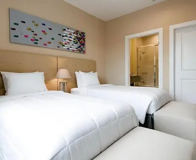 two beds in a room with white sheets at Super Close to Disney Magic Stays in Orlando