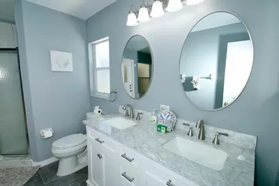 a bathroom with two sinks and a toilet and a mirror at Family Escape Close to parks in Orlando