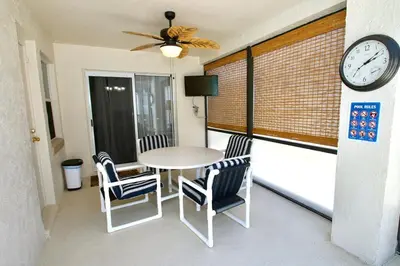 a balcony with a table and chairs and a clock at Family Escape Close to parks in Orlando