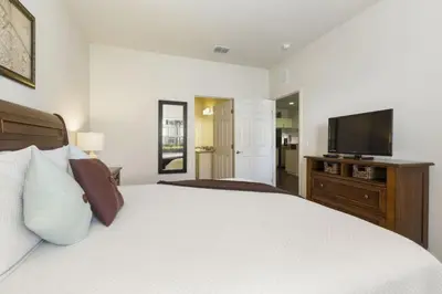 a bedroom with a bed and a flat screen tv at Amazing 3Bdr House near Disney 16106 in Kissimmee