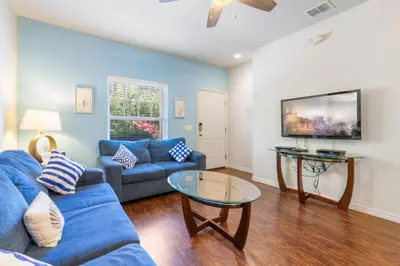 a living room with a blue couch and a table at Amazing 3BDR House near Disney 12102 in Kissimmee
