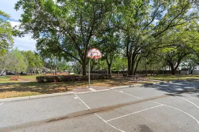a basketball hoop in a parking lot with a basketball court at Amazing 3BDR House near Disney 12102 in Kissimmee