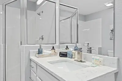 a white bathroom with a sink and a mirror at Finding Nemo House at Caribe Cove Resort - Sage Vacations in Kissimmee