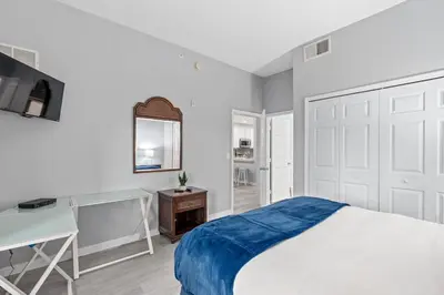 a bedroom with a bed and a desk and a mirror at Finding Nemo House at Caribe Cove Resort - Sage Vacations in Kissimmee