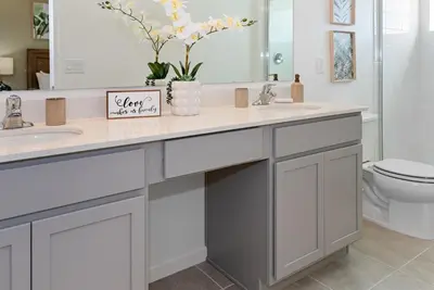 a bathroom with two sinks and a mirror at 10251 EBB Tide Lane in Orlando