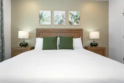 a bedroom with a large white bed with two lamps at 10251 EBB Tide Lane in Orlando