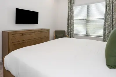 a bedroom with a bed and a dresser and a television at 10251 EBB Tide Lane in Orlando
