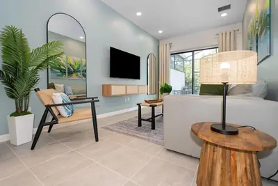 a living room with a bed and a table with a lamp at 10251 EBB Tide Lane in Orlando