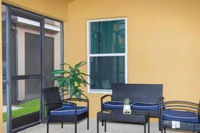 a patio with chairs and a table and a window at 4 Bedroom with Pool near to Disney in Kissimmee