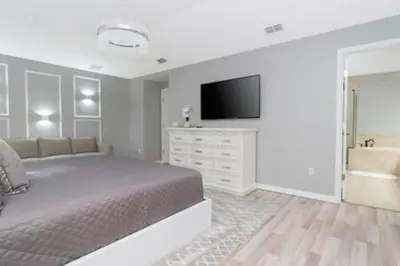 a bedroom with a bed and a flat screen tv at 4 Bedroom with Pool near to Disney in Kissimmee