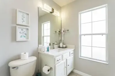 a white bathroom with a sink and a mirror at Beautiful 4 Bedroom Pool Home Near Disney in Kissimmee