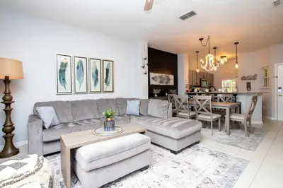 a living room with a couch and a table at 3 Bedrooms Home W Pool just 6 miles from Disney in Kissimmee