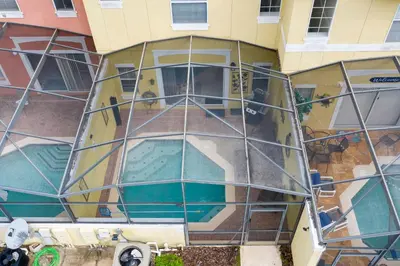 an external view of a building with a swimming pool at 3 Bedrooms Home W Pool just 6 miles from Disney in Kissimmee