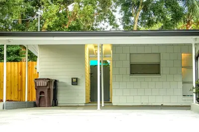 a white house with a trash can and a yellow fence at Exquisite Luxury Villa with Pool in Prime Location in Orlando
