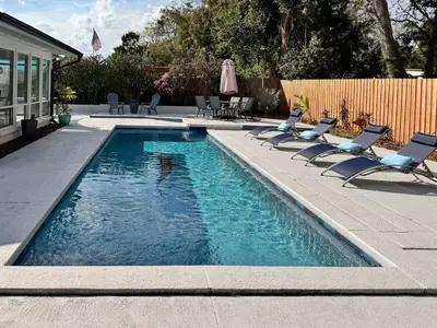 a swimming pool with lounge chairs next to a house at Exquisite Luxury Villa with Pool in Prime Location in Orlando