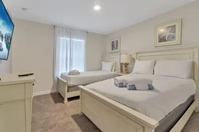 a white bedroom with two beds and a window at Your 4BDR Vacation Home - 4838 in Kissimmee