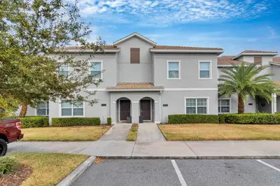 a large white house with a palm tree at Your 4BDR Vacation Home - 4838 in Kissimmee