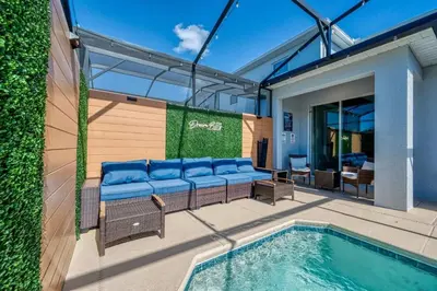 a patio with a couch and a swimming pool at Casa Temática c/ Piscina no Storey Lake in Kissimmee
