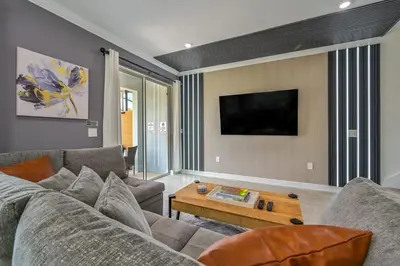 a living room with a couch and a table at Casa Temática c/ Piscina no Storey Lake in Kissimmee