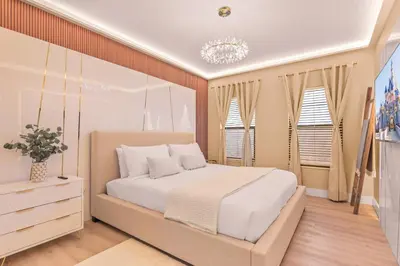 a bedroom with a large bed and a chandelier at Luxury Stay Walk to SeaWorld Minions Room in Orlando