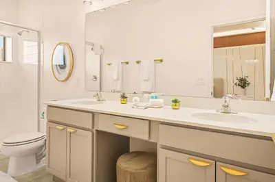 a bathroom with a sink and a toilet and a mirror at Luxury Stay Walk to SeaWorld Minions Room in Orlando
