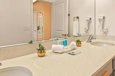 a bathroom with two sinks and a large mirror at Luxury Stay Walk to SeaWorld Minions Room in Orlando