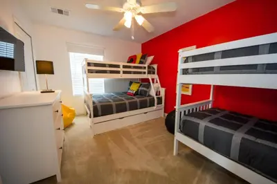 a bedroom with two bunk beds and a red wall at Villa Bella - 4 Bedrooms in Kissimmee