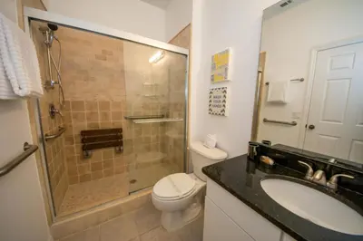 a bathroom with a shower and a toilet and a sink at Villa Bella - 4 Bedrooms in Kissimmee