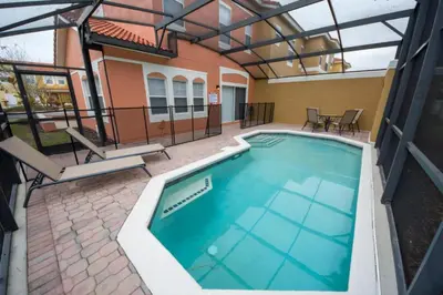 a swimming pool with a pergola and a house at Villa Bella - 4 Bedrooms in Kissimmee
