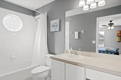 a white bathroom with a toilet and a sink at Family Fun Kissimmee Retreat in Kissimmee