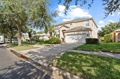 a house with a driveway and a garage at Family Fun Kissimmee Retreat in Kissimmee