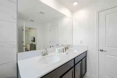 a white bathroom with two sinks and a mirror at Casa 4Q com Piscina Privativa e Temas Disney in Kissimmee