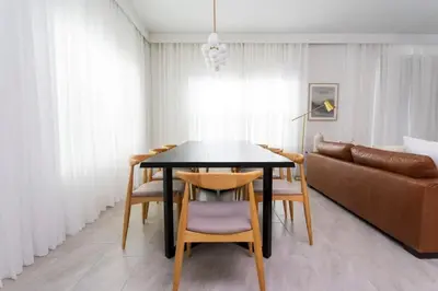 a dining room with a table and chairs and a couch at Casa 5 Quartos com Piscina e Tema Disney in Kissimmee