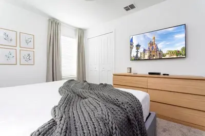a bedroom with a bed and a tv on the wall at Casa 5 Quartos com Piscina e Tema Disney in Kissimmee