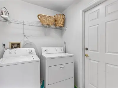a white laundry room with a washer and dryer at Sunny Getaway with Private Pool, Spa & Fenced Yard in Kissimmee