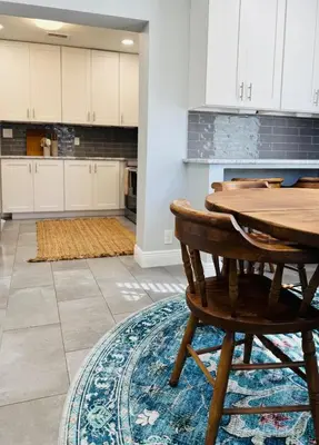 a kitchen with a wooden table and a rug at 3BR Oasis DT ORL, Full Kitchen & Fenced Yard! in Orlando