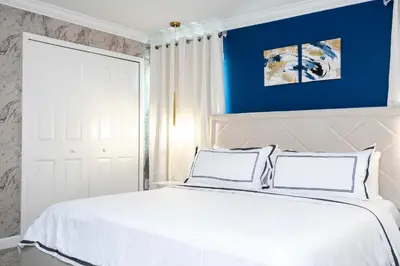 a bedroom with a white bed with a blue wall at Magical Stay Mickey and Harry Potter Rooms in Kissimmee