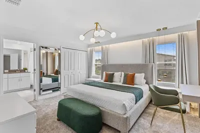 a bedroom with a bed and a green chair at New Home 04 Bedrooms At Storey Lake in Kissimmee