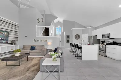 a living room and kitchen with a couch and a table at 5BR Kissimmee Home Pool and Game Room Fun in Kissimmee