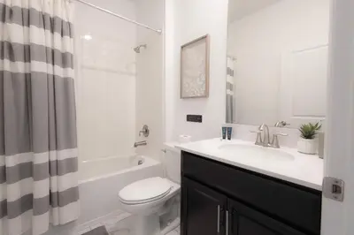 a white bathroom with a sink and a toilet at Fantasy Stay in 5 bed at Storey Lake in Kissimmee