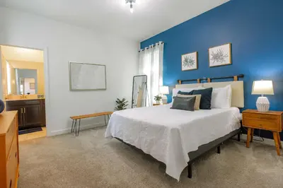 a bedroom with a large bed with a blue wall at Fantasy Stay in 5 bed at Storey Lake in Kissimmee